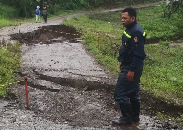 Longsor Makan Jalan Penghubung Desa Manusasi dan Sainam, Bhabinkamtibmas Turun Pasang Tanda Peringatan